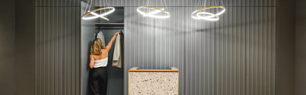 Young professional in office using sleek modern cloakroom with abstract lights