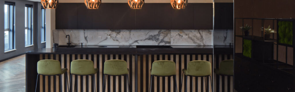 Communal area in sleek modern office with a marble island surrounded by chairs