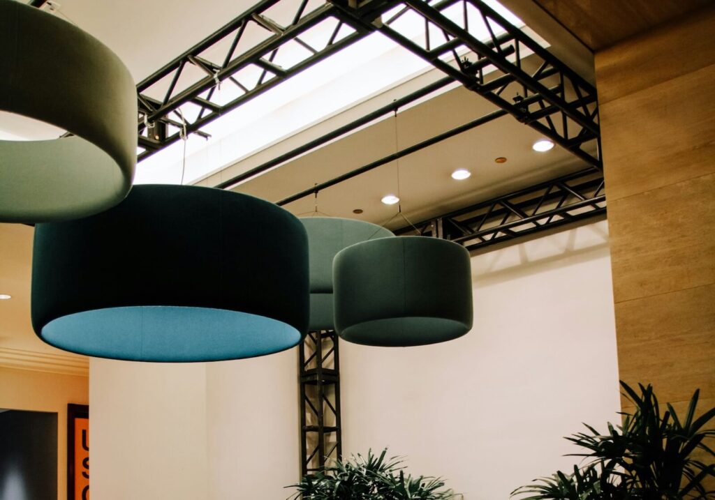 Three velvet light shades on office ceiling in different shades of blue and green