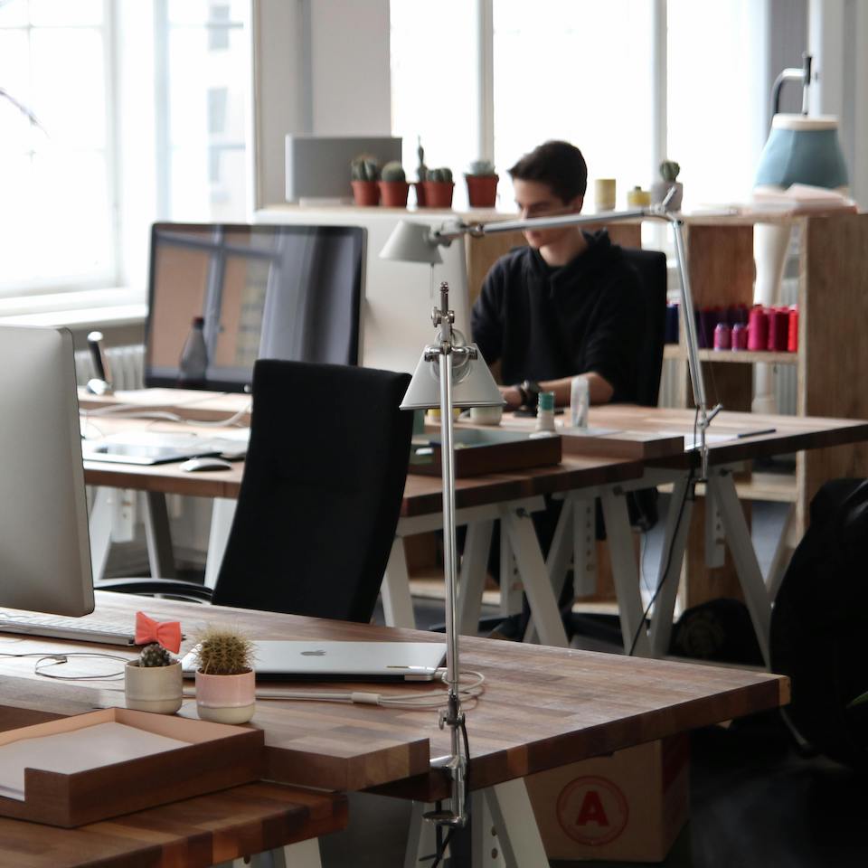 Empty office chair with computers on desk in modern well-lit work environment