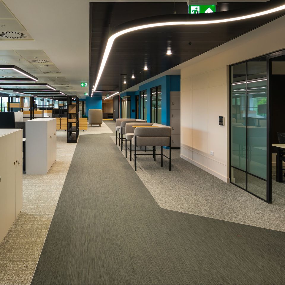 Colourful well lit hallway with bespoke lighting and breakout spaces