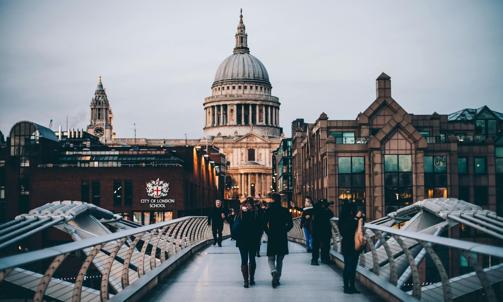View of City of London School and St Paul's Cathedral with people walking across a bridge